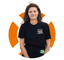 Porträt von Johanna, Fundraising-Mitarbeiterin bei Sea-Eye, in Sea-Eye-Shirt vor orangefarbenem Hintergrund