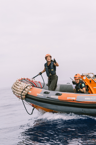 Two Sea-Eye crew members on an orange RHIB during training