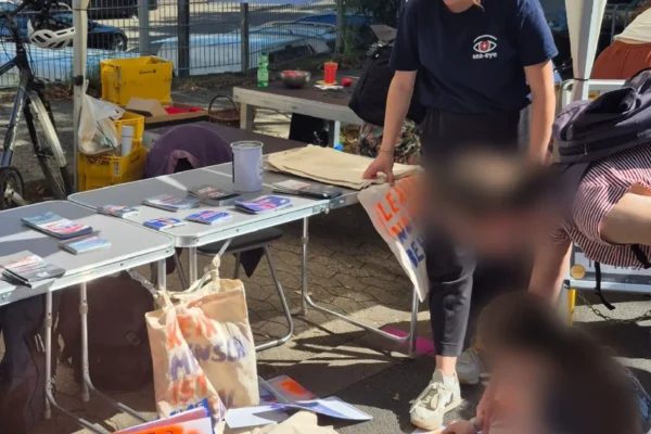 Ehrenamtliche von Sea-Eye e.V. an einem Infostand mit Flyern, Taschen und Schablonen auf dem Boden bei einem Straßenfest in Düsseldorf