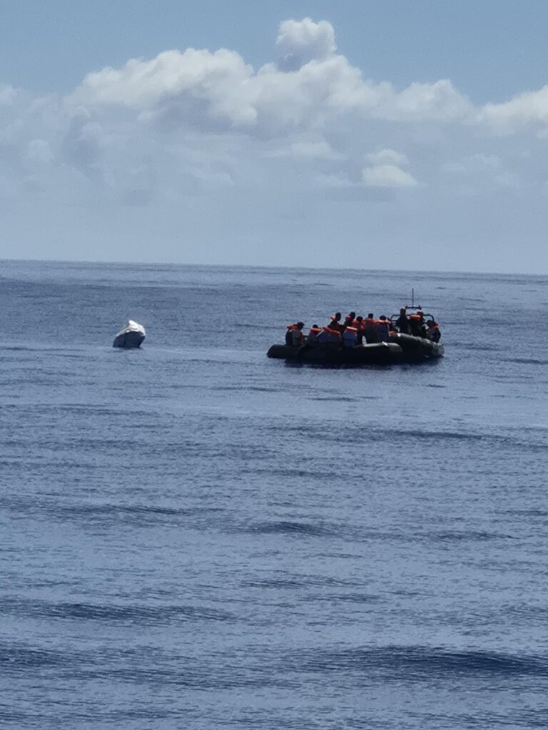 RHIB mit mehreren Personen in Rettungswesten auf offenem Meer neben einem Schlauchboot